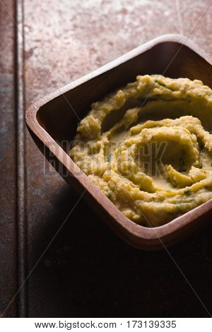 Puree beans in a wooden bowl on the table square vertical