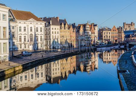 GHENT BELGIUM - 19TH FEB 2016: A view of beautiful old buildings along Korenlei and the River Leie in Ghent Old Town during the day. Reflections can be seen in the water.