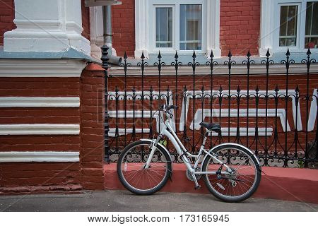 Bike stands on the street beside the red house