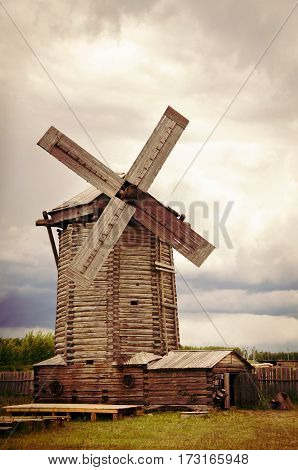 The windmill in the field in cloudy weather