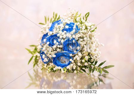 Beautiful wedding bouquet of blue and white flowers on the glass table