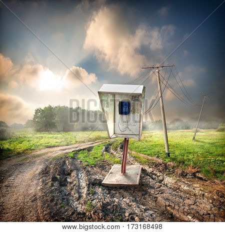 Old payphone on a road in the field