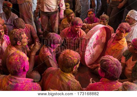 Barsana, India - March 17, 2016: Devotees play music covered with colors during the Holi celebration in Barsana, India. Holi is the most celebrated religious festival in India.