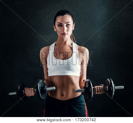 Athletic Young Woman Doing A Fitness Workout Against Black Background. Attractive Fitness Girl Pumpi