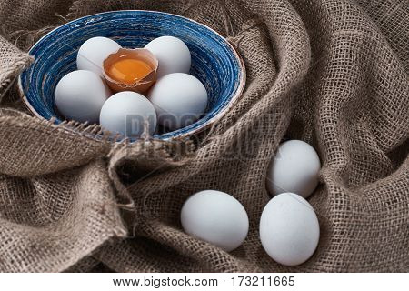 Ecological natural fresh eggs collected in the plate for cooking on the fabric.