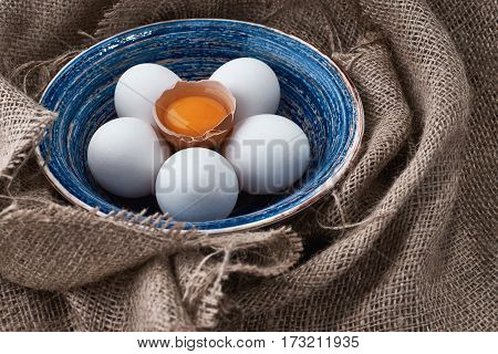 Ecological natural fresh eggs collected in the plate for cooking on the fabric.