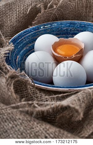 Ecological natural fresh eggs collected in the plate for cooking on the fabric.