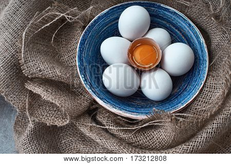 Ecological natural fresh eggs collected in the plate for cooking on the fabric.