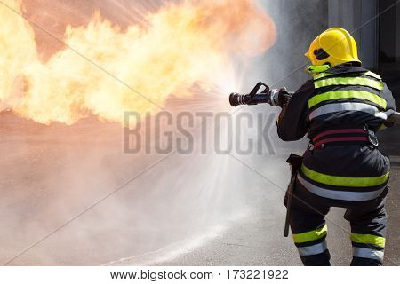 Fireman fighting fire during training. Firefighter in action.