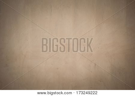 closeup surface detail of old beige-brown grunge stucco concrete wall with vignette effect abstract rough texture for background or backdrop in architecture and structure concepts