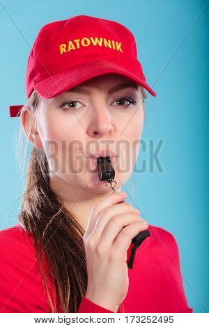 Lifeguard Woman In Cap On Duty Blowing Whistle.