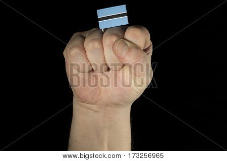 Man Hand Fist With Botswanan Flag Isolated On Black Background