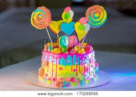 large birthday sprinkled with berries and flowers cake on the table