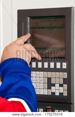 Automated workplace, engineer's hand on the working computer panel of industrial CNC machine