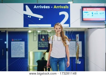 Beautiful Young Tourist Girl With Backpack And Carry On Luggage In International Airport