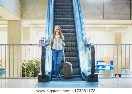Tourist Girl With Backpack And Carry On Luggage In International Airport, On Escalator