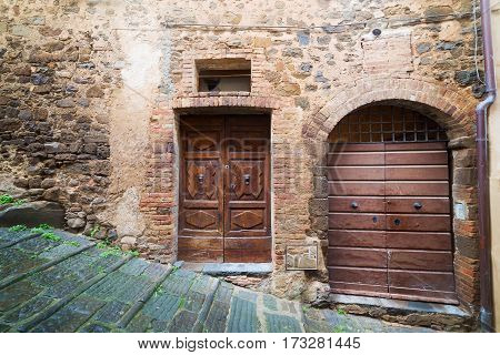 wooden doors in a rustic wall in Montalcino Tuscany