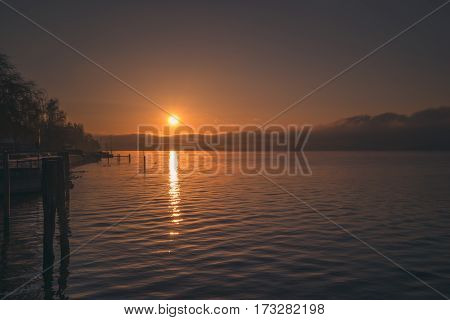 A calm orange sunset on the shore of a lake in germany, bodensee