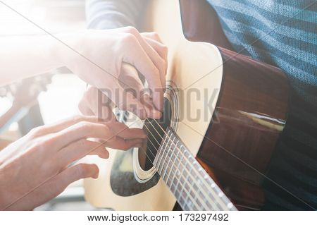 Masterclass learning to play the guitar outdoors. Musical education.