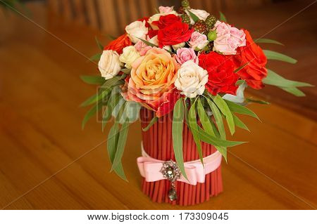 Tenderless Bouquet With Bow And Ribbons In Gaudy Red And Orange Colours, Staying On Brown Background