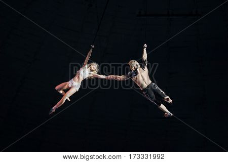 Stunt aerialists men and women in the circus. Love, danger, and romance concept.