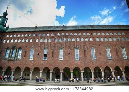 STOCKHOLM SWEDEN - AUGUST 20 2016: Tourists walk and visit Stockholm City Hall ( Stadshuset ) Venetian-style colonnade that divides the City Hall in Stockholm Sweden on August 20 2016.