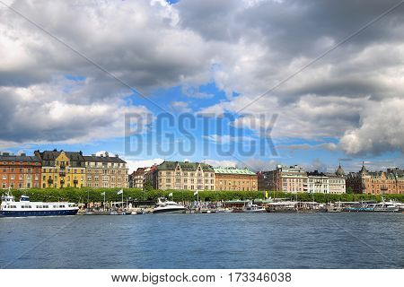 STOCKHOLM SWEDEN - AUGUST 20 2016: Many people walk and visit on Strandvagen street on Ostermalm distric with touristic sightseeing boats in Stockholm Sweden on August 20 2016.
