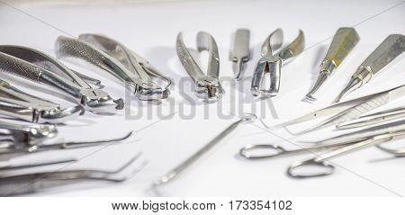 Dental Instruments some arranged and some not arranged on white table arranged in some pattern- concept - Team work (both organised and disorganised)