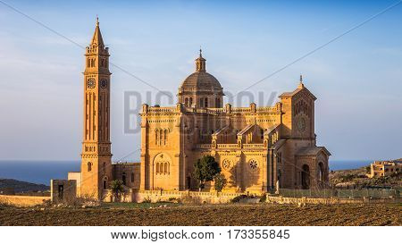 Gozo Malta - The Basilica of the National Shrine of the Blessed Ta' Pinu at sunset with clear blue sky on a summer day