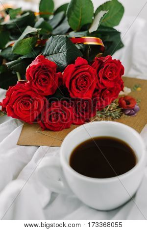 a bouquet of red roses coffee card with congratulations supply in bed