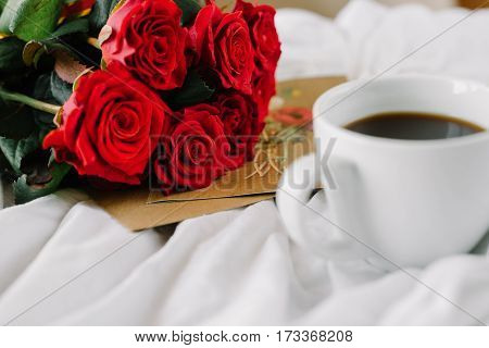 a bouquet of red roses coffee card with congratulations supply in bed