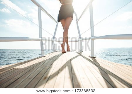 Cropped back view photo of young amazing girl standing on the yacht