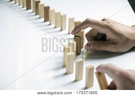 A Male Hand Stopping The Domino Effect. Retro Style Image Executive And Risk Control Concept