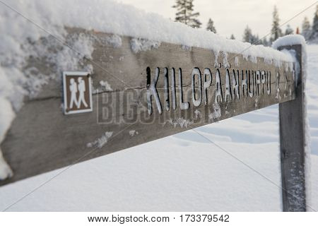Wooden directions sign in winter in Finnish Lapland, Saariselka, Finland.