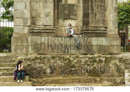 CARTAGO, COSTA RICA - JUNE 17, 2012: Unidentified people sit at the entrance to the ruins of the Santiago Apostol cathedral in Cartago Costa, Rica.