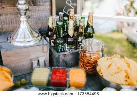 Different brands of beer bottles with snacks