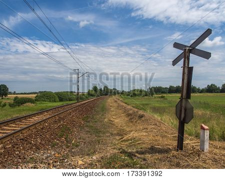 Karpiska Poland - June 28 2016: View over railroad tracks and meadow by a railway crossing
