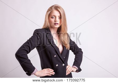 Sexy woman with no bra in fashion suit on blavk background in studio photo