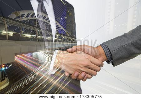 Double exposure of Business handshake. Business hands shake and business people concept. Two men shaking hands on bangkok city background. Partnership Deal