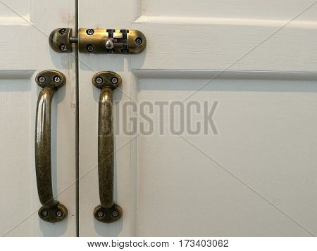 Modern vintage style door handle and slide lock on white natural wooden door white door space on the right with lock and handle on the left