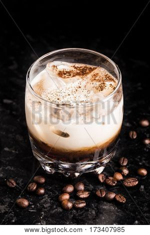 White russian cocktail with coffee beans on a marble table