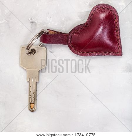 Key With Leather Heart Shape Trinket On Concrete