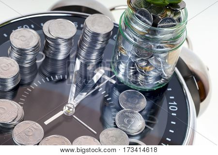 coins with plant and clock isolated on white background. savings concept concept of time and money. copy space for text.