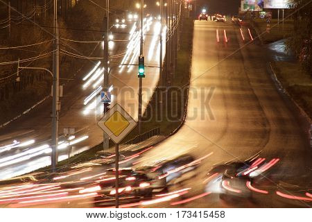 Cars drive on highway in the night city. Urban style.