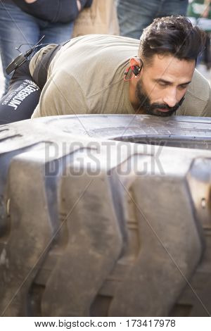 NEW YORK - 11 NOV 2016: US Marine veteran Guy Valentino attempts the Guinness World Record for fastest one mile tire flipping of 450lb tire on 5th Ave at the Americas Parade on Veterans Day.