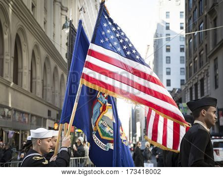 NEW YORK - 11 NOV 2016: American Flag and flag of US Navy, USN carried by personel marching in Americas Parade up 5th Avenue on Veterans Day in Manhattan.