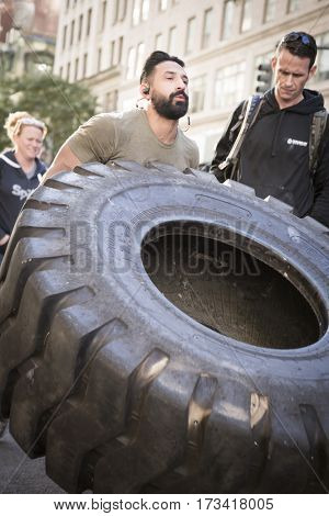 NEW YORK - 11 NOV 2016: US Marine veteran Guy Valentino attempts the Guinness World Record for fastest one mile tire flipping of 450lb tire on 5th Ave at the Americas Parade on Veterans Day.