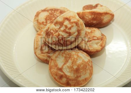 Poffertjes Dutch small fluffy pancakes served with powdered sugar and butter.