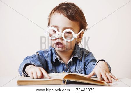 Expressive girl child reading a magic book. (Education knowledge wisdom magic childhood concept)