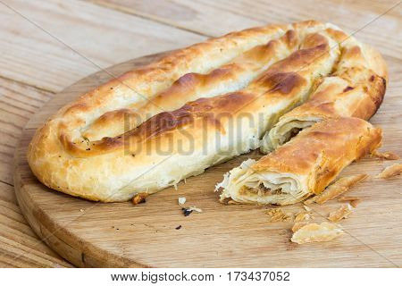 Sliced Burek With Meat On The Wooden Board. Rustic Food.